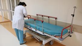 Медсестра стоит возле больничной кушетки