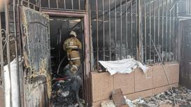 Пожарный входит в сгоревший магазин в селе Чапай