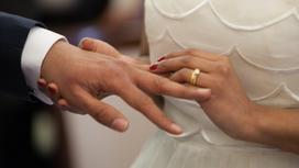Девушка надевает мужу кольцо на свадьбе