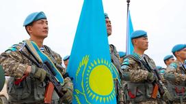 Казахстанские военнослужащие держат флаг Казахстана