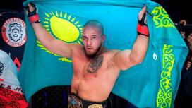 Артем Резников держит флаг Казахстана