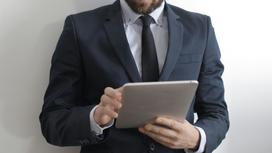 Мужчина в костюме смотрит в планшет