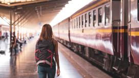 Девушка стоит у перрона рядом с поездом