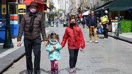 Мужчина с двумя детьми в масках на улице