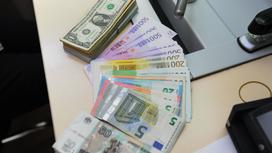 Купюры инсотранных валют лежат на столе в обменном пункте
