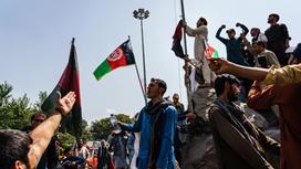 Мужчины держат флаг Афганистана