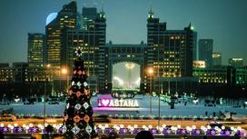 В высотных домах светятся окна. На большой площади стоит украшенная новогодняя елка, везде светится иллюминация и надпись «Я люблю Астану»