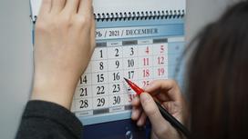 Девушка обводит дату в календаре