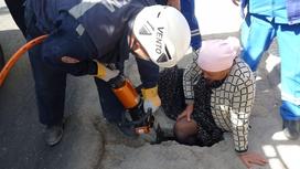 Спасатели помогают женщине выбраться из ямы