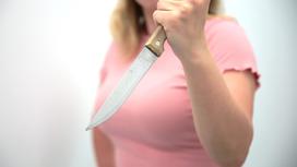 Женщина держит нож
