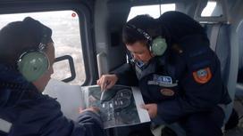 Сотрудники ДЧС в вертолете изучают карту