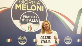 Джорджа Мелони с табличкой, на которой написано "Спасибо, Италия""