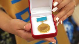 Медаль "Алтын белгi" в руках у женщины