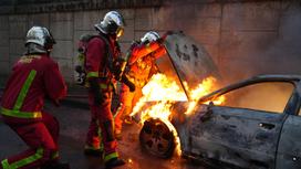 Пожарные тушат машину, которую подожгли протестующие