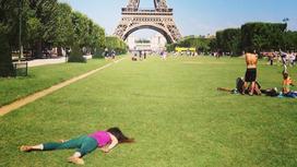 Художница Стефани Ли Роуз лежит на газоне перед Эйфелевой башней