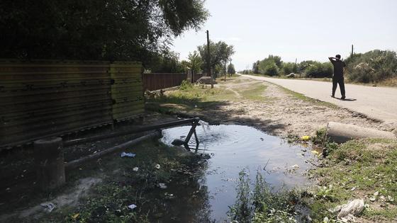 Мужчина идет по дороге возле колонки с водой Мужчина идет по дороге возле колонки с водой