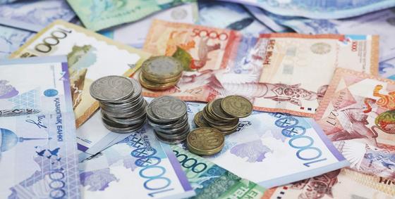 Монеты лежат на купюрах тенге Монеты лежат на купюрах тенге