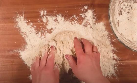 Тесто для пиццы вымешивается на столе руками Тесто для пиццы вымешивается на столе руками