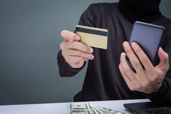 Мужчина держит смартфон и банковскую карту Мужчина держит смартфон и банковскую карту