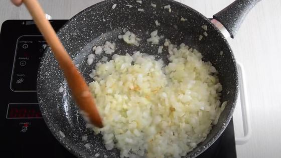 Лук жарят в сковородке и мешают лопаткой Лук жарят в сковородке и мешают лопаткой