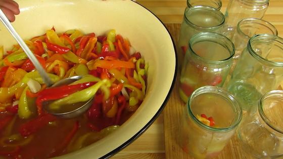 Кусочки перца половником раскладывают в банки Кусочки перца половником раскладывают в банки