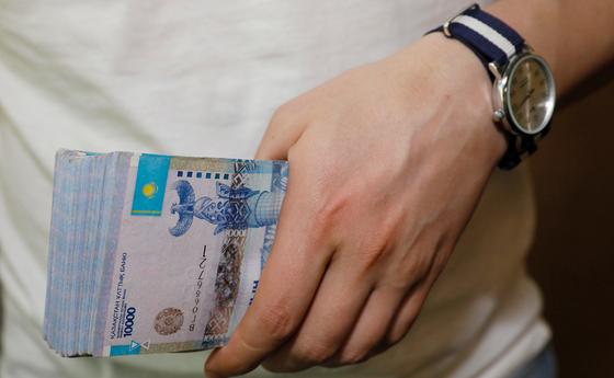 Мужчина держит в руках пачку денег Мужчина держит в руках пачку денег