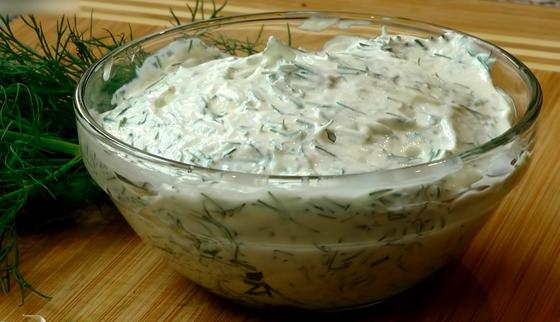 Готовый чесночный соус из сметаны с укропом в миске Готовый чесночный соус из сметаны с укропом в миске