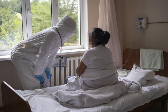 Женщина сидит на кровати в больнице Женщина сидит на кровати в больнице
