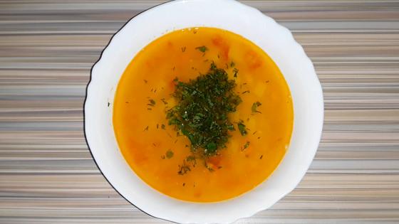Готовый суп из красной чечевицы и курицы в тарелке на столе Готовый суп из красной чечевицы и курицы в тарелке на столе