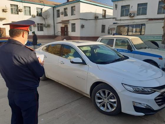 Полицейский стоит рядом с изъятой машиной в Туркестанской области Полицейский стоит рядом с изъятой машиной в Туркестанской области