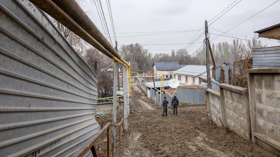Люди идут по улице в грязи Люди идут по улице в грязи