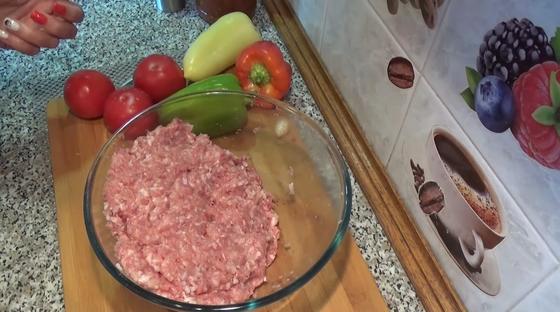 Мясной фарш в стеклянной миске, овощи на доске Мясной фарш в стеклянной миске, овощи на доске