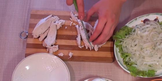 Измельчение куриного филе ножом на доске для салата Измельчение куриного филе ножом на доске для салата