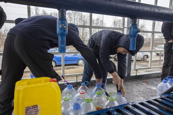 Мужчины набирают воду на колонке Мужчины набирают воду на колонке