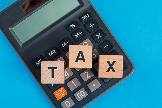 Кубики с надписью Tax лежат на калькуляторе Кубики с надписью Tax лежат на калькуляторе