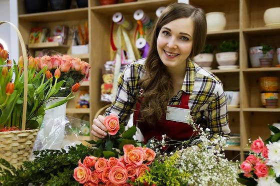Девушка продает цветы в магазине Девушка продает цветы в магазине