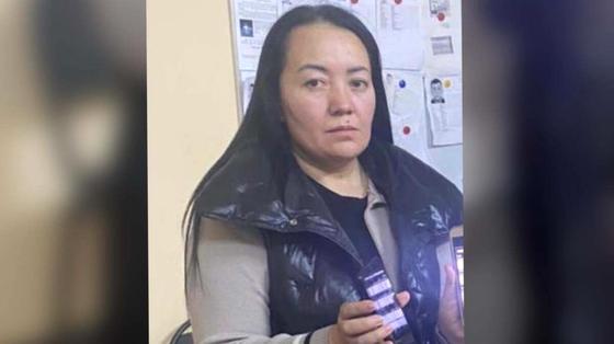 Женщина, подозреваемая в мошенничестве, держит в руках телефон Женщина, подозреваемая в мошенничестве, держит в руках телефон