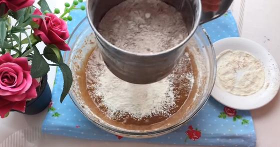 Просеивание муки в миску с какао Просеивание муки в миску с какао
