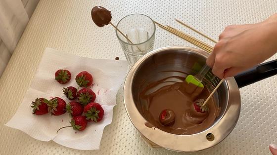 Клубнику макают в шоколад Клубнику макают в шоколад