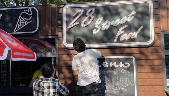 Мужчина собирается снять часть вывески Мужчина собирается снять часть вывески