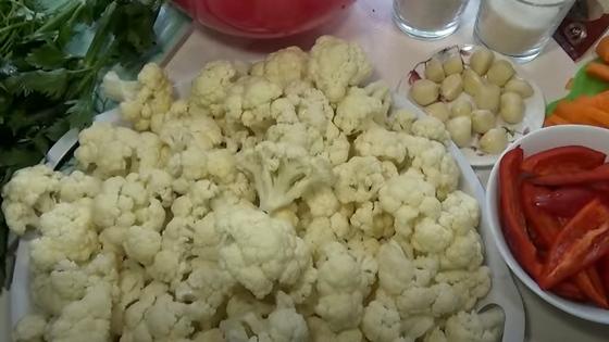 Соцветия цветной капусты, дольки чеснока, кусочки болгарского перца на тарелках Соцветия цветной капусты, дольки чеснока, кусочки болгарского перца на тарелках