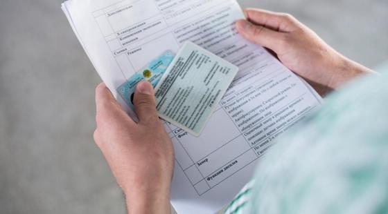 Мужчина держит удостоверение и техпаспорт Мужчина держит удостоверение и техпаспорт