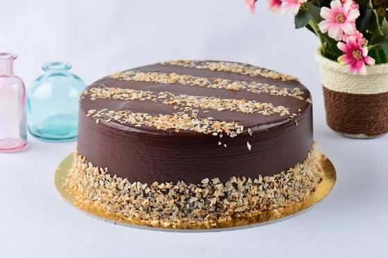Шоколадный торт, покрытый глазурью и украшенный ореховой крошкой Шоколадный торт, покрытый глазурью и украшенный ореховой крошкой