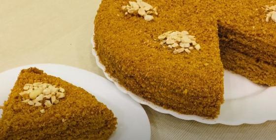 Круглый медовик и отрезанный от него кусок на тарелках Круглый медовик и отрезанный от него кусок на тарелках