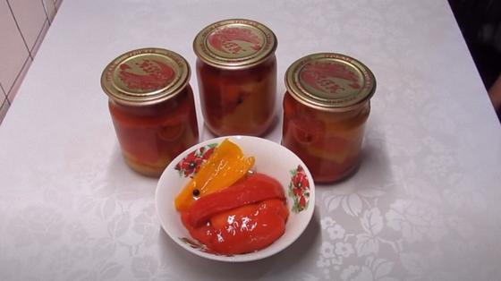 Кусочки маринованного перца в миске и в закрытых банках Кусочки маринованного перца в миске и в закрытых банках