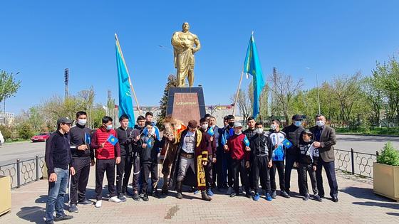 мужчина поднимает верблюда на площади мужчина поднимает верблюда на площади