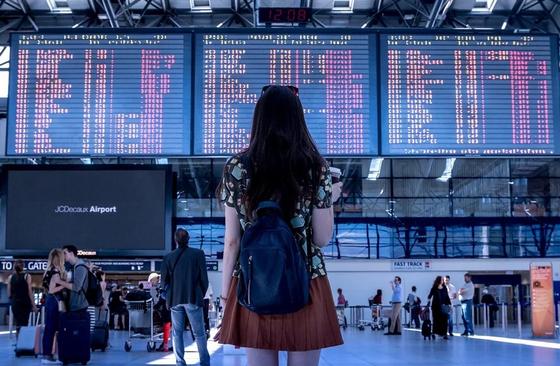 Девушка смотрит на табло в аэропорту Девушка смотрит на табло в аэропорту