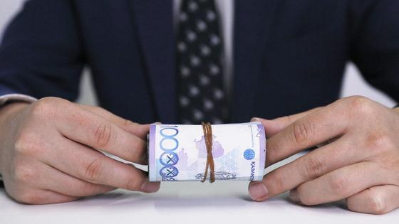 Мужчина в пиджаке держит в руках деньги Мужчина в пиджаке держит в руках деньги