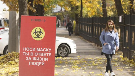 Девушка в маске рядом с билбордом Девушка в маске рядом с билбордом