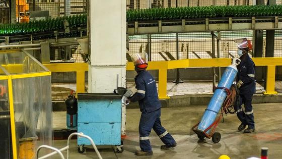 Рабочие в спецодежде перевозят оборудование Рабочие в спецодежде перевозят оборудование